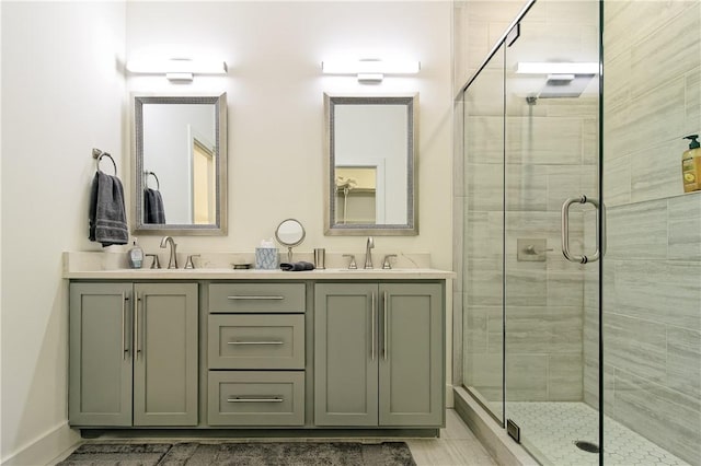 bathroom featuring double vanity, a stall shower, and a sink