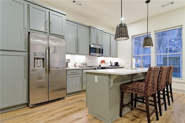 kitchen featuring light wood finished floors, visible vents, and appliances with stainless steel finishes