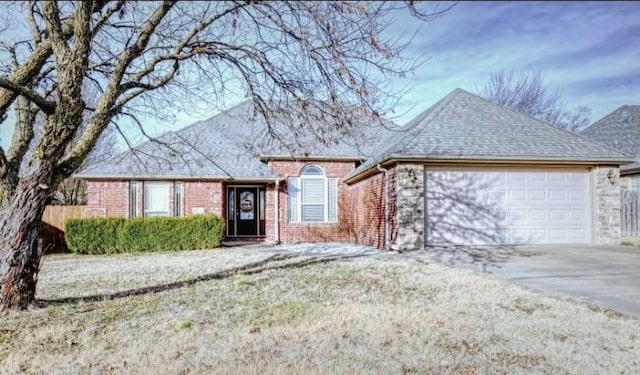 ranch-style home featuring a garage, a shingled roof, concrete driveway, and brick siding