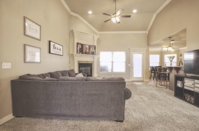 carpeted living room with ornamental molding, a glass covered fireplace, high vaulted ceiling, and baseboards