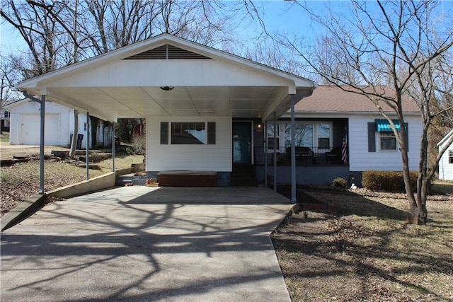 view of front facade featuring a carport, concrete driveway, roof with shingles, and an outdoor structure