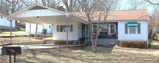 view of front of property with a carport, a chimney, and roof with shingles