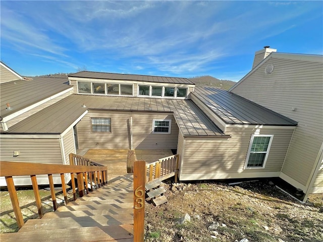 back of house with metal roof and a standing seam roof