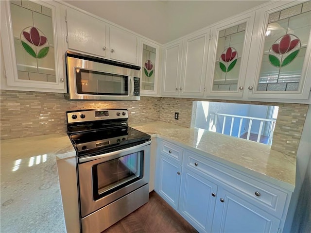 kitchen with glass insert cabinets, white cabinetry, appliances with stainless steel finishes, and decorative backsplash