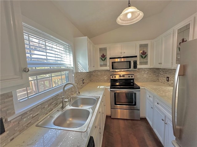 kitchen with dark wood-style flooring, stainless steel appliances, lofted ceiling, white cabinets, and a sink