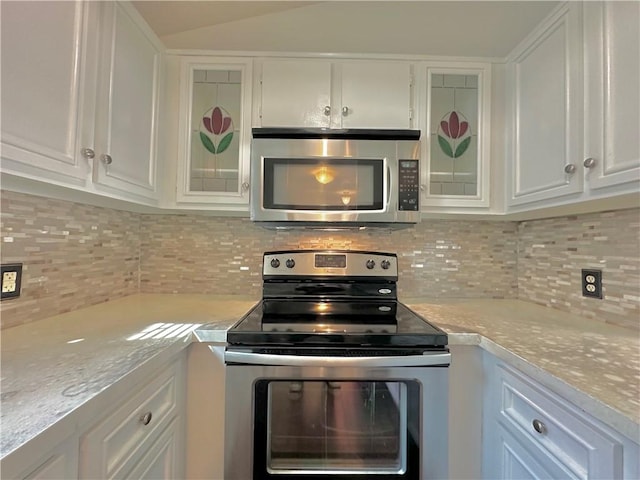 kitchen with stainless steel appliances, white cabinetry, light countertops, backsplash, and glass insert cabinets