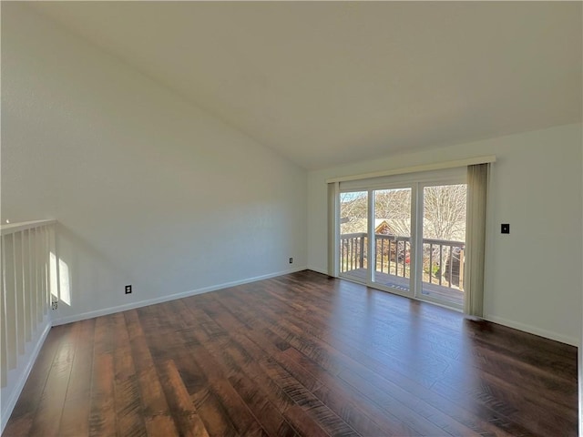 unfurnished room with dark wood-style flooring, vaulted ceiling, and baseboards