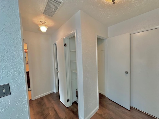 interior space with visible vents, a textured ceiling, and wood finished floors