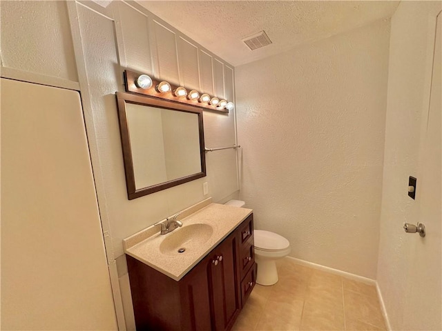 bathroom featuring visible vents, a textured wall, toilet, vanity, and a textured ceiling