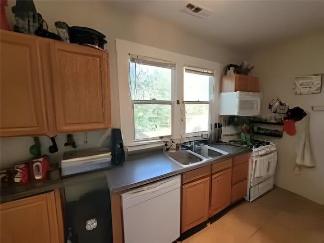 kitchen featuring white appliances and a sink