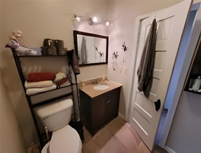 bathroom featuring vanity, toilet, and baseboards