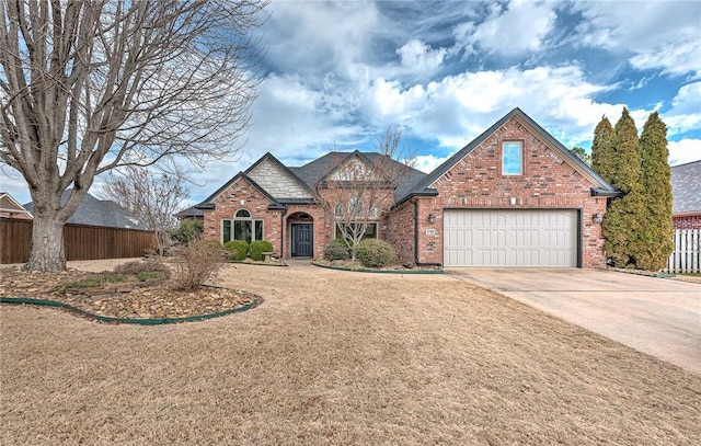 view of front of home with an attached garage, fence, concrete driveway, and brick siding