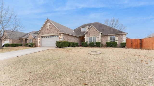 view of front of home featuring a garage, brick siding, fence, and driveway