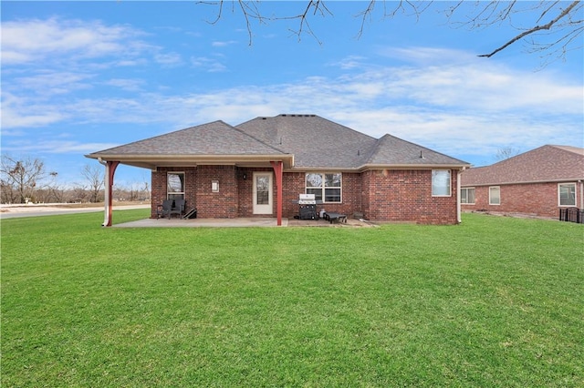 115 NE Lake Forest Ln, Bentonville, AR 72712 - rear view of house featuring a shingled roof, brick siding, a lawn, and a patio
