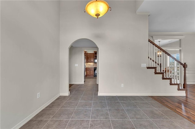 115 NE Lake Forest Ln, Bentonville, AR 72712 - entrance foyer featuring arched walkways, stairway, tile patterned flooring, and baseboards