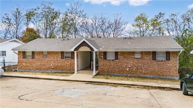 ranch-style house with brick siding, roof with shingles, and fence