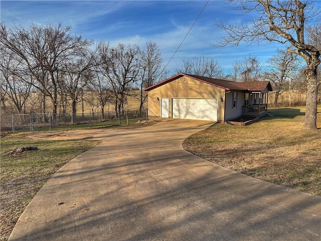 view of side of property with a yard, driveway, an attached garage, and fence