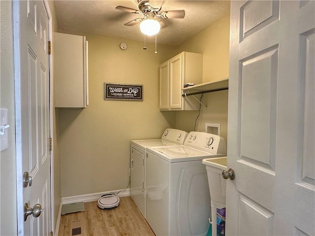 washroom with a ceiling fan, baseboards, independent washer and dryer, cabinet space, and light wood finished floors