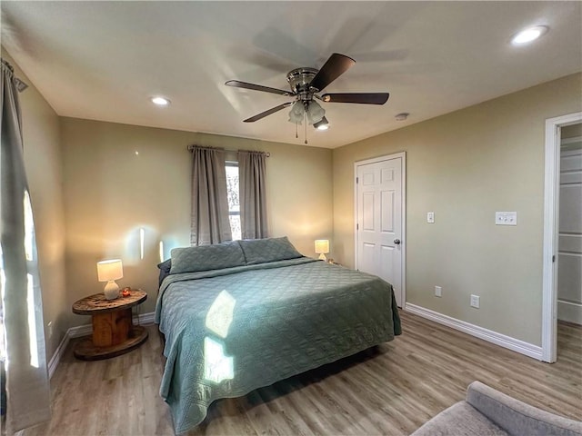 bedroom with a ceiling fan, baseboards, wood finished floors, and recessed lighting