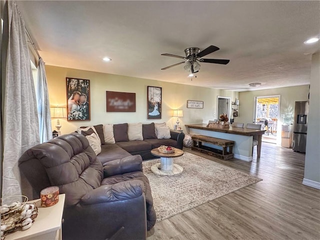 living room featuring recessed lighting, ceiling fan, baseboards, and wood finished floors