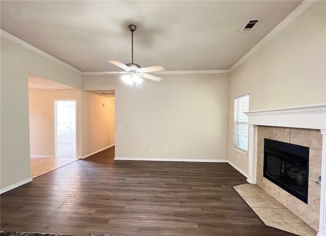 unfurnished living room with baseboards, a fireplace, wood finished floors, and crown molding