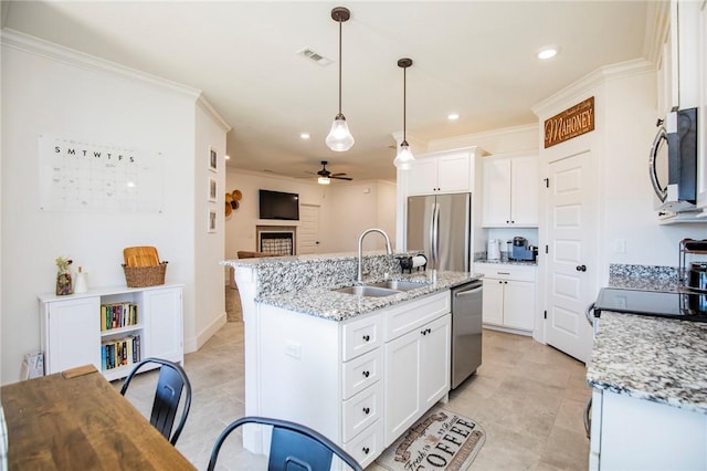 kitchen featuring a fireplace, a sink, visible vents, appliances with stainless steel finishes, and crown molding