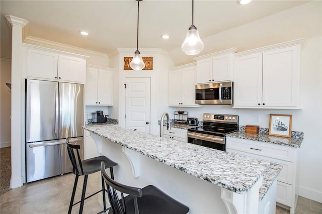 kitchen featuring stainless steel appliances, a breakfast bar, and white cabinetry