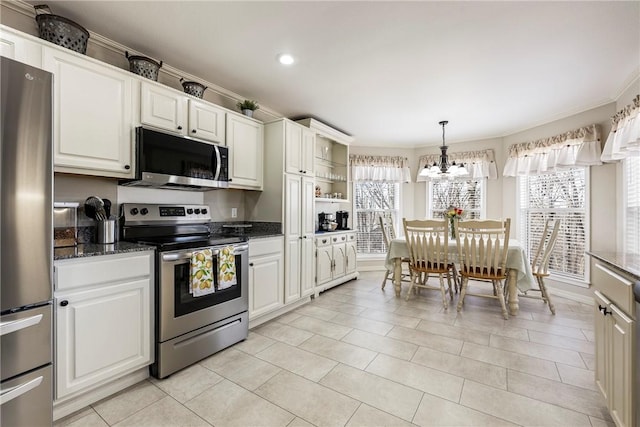 kitchen featuring dark stone counters, appliances with stainless steel finishes, crown molding, pendant lighting, and a notable chandelier