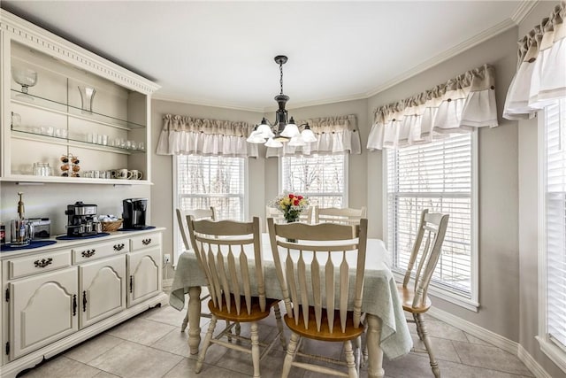 dining area featuring light tile patterned floors, ornamental molding, baseboards, and a notable chandelier