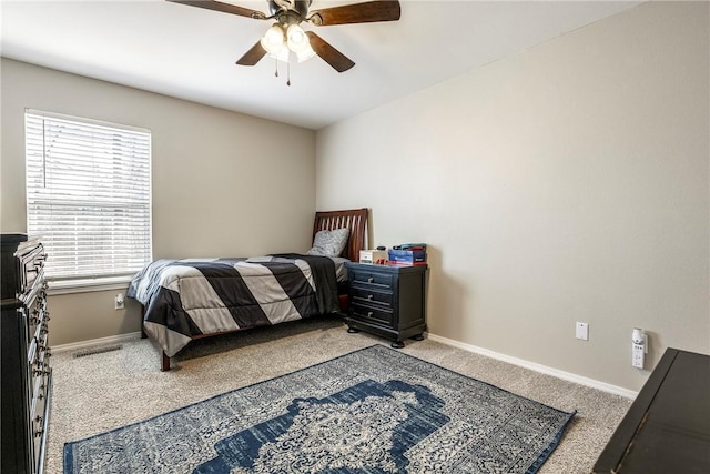 carpeted bedroom with visible vents, baseboards, and a ceiling fan