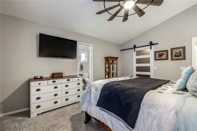 bedroom with light carpet, a barn door, vaulted ceiling, and ensuite bathroom