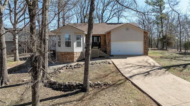 single story home featuring a garage, stone siding, a shingled roof, and concrete driveway