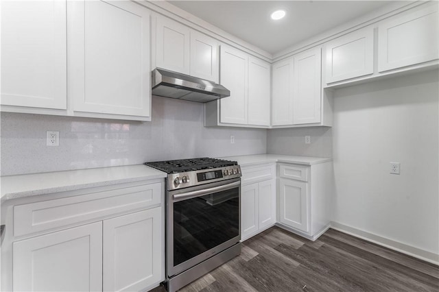 kitchen with under cabinet range hood, dark wood-type flooring, baseboards, white cabinets, and gas stove