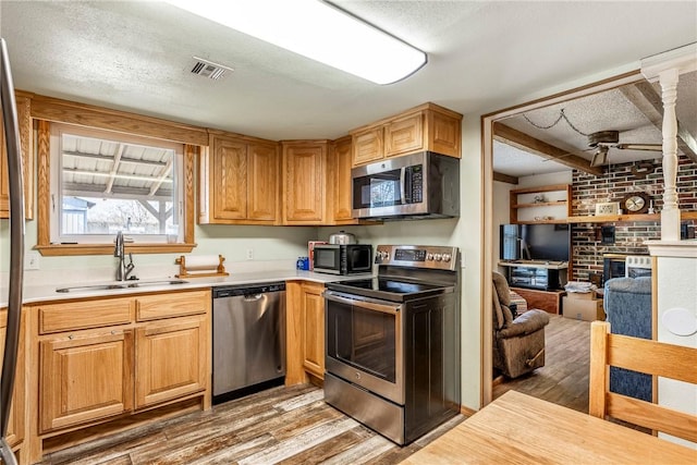 kitchen featuring visible vents, a sink, light countertops, appliances with stainless steel finishes, and light wood-type flooring