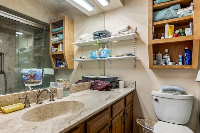 full bathroom with vanity, a shower stall, and toilet