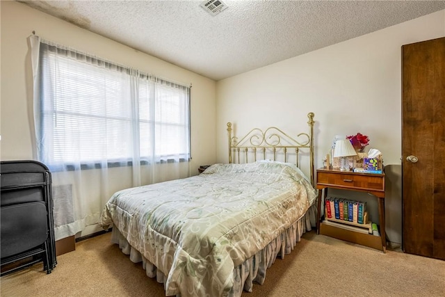 carpeted bedroom with visible vents and a textured ceiling