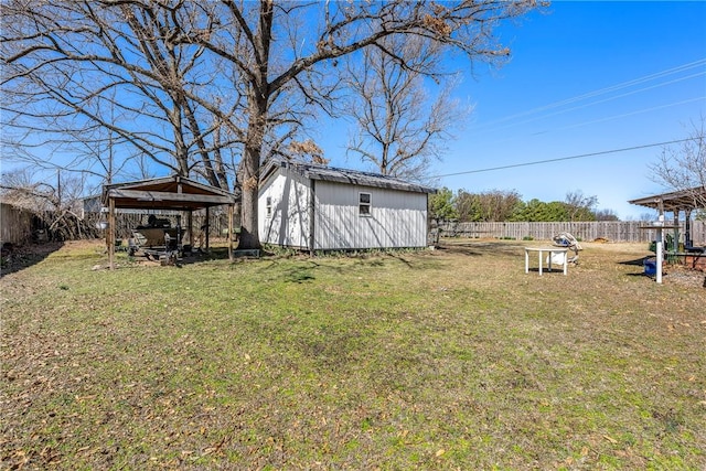 view of yard featuring a fenced backyard, a detached carport, and an outdoor structure