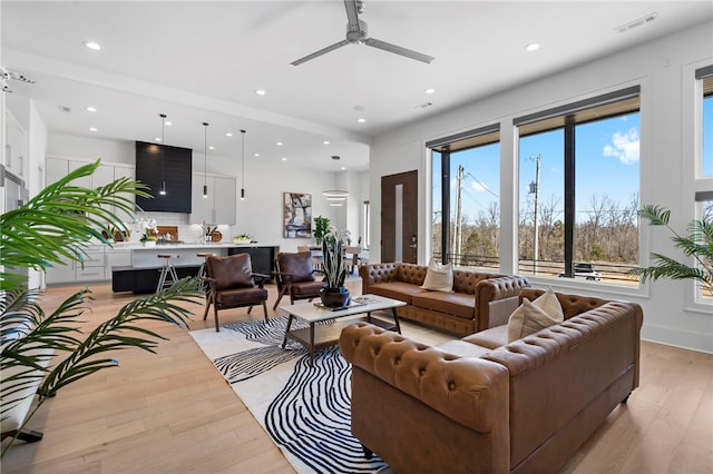 living area featuring recessed lighting, visible vents, baseboards, a ceiling fan, and light wood-style floors