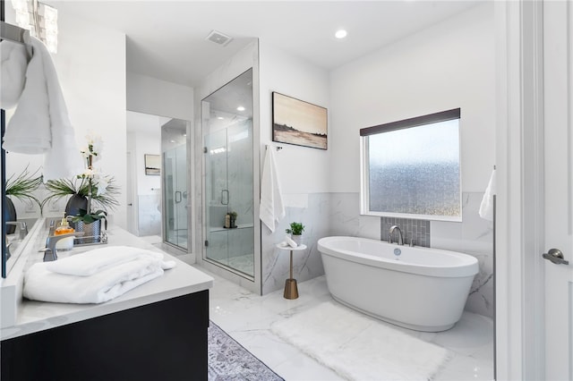 full bathroom with a marble finish shower, visible vents, marble finish floor, vanity, and a freestanding tub