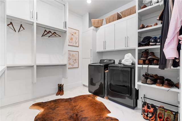 laundry area with marble finish floor, cabinet space, and separate washer and dryer