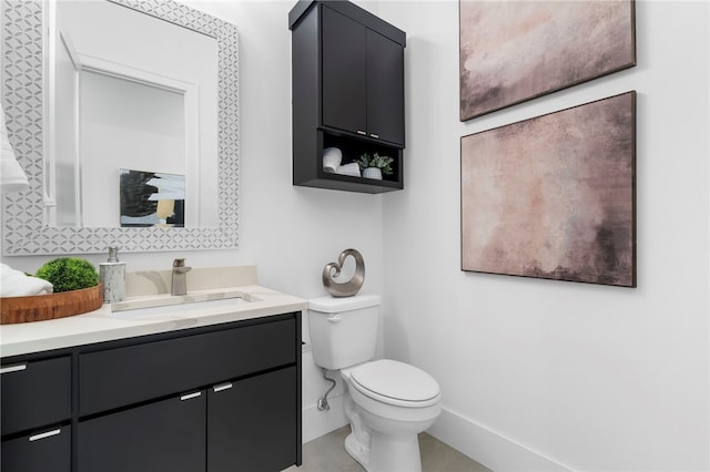 bathroom featuring baseboards, vanity, and toilet