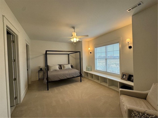 bedroom featuring baseboards, visible vents, a ceiling fan, and light colored carpet