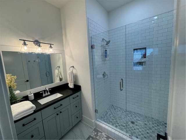 full bath with marble finish floor, baseboards, a shower stall, and vanity