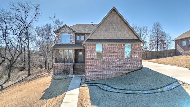 view of front of home featuring brick siding and fence