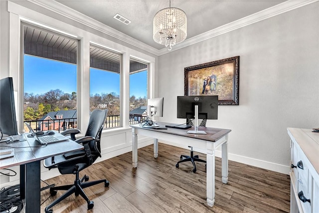 home office with ornamental molding, visible vents, a notable chandelier, and wood finished floors