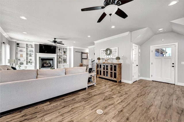 living room featuring a barn door, recessed lighting, wood finished floors, and crown molding