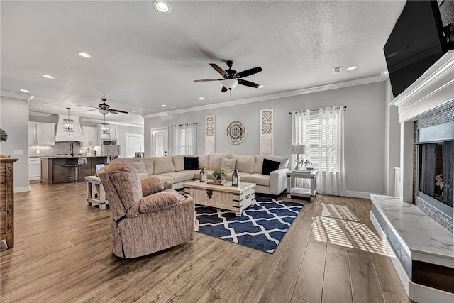 living room featuring recessed lighting, ceiling fan, and a tiled fireplace