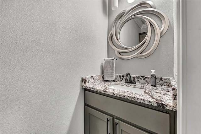 bathroom featuring a textured wall and vanity