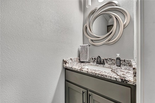 bathroom with a textured wall and vanity