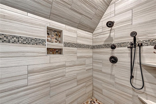 full bathroom featuring tiled shower and vaulted ceiling